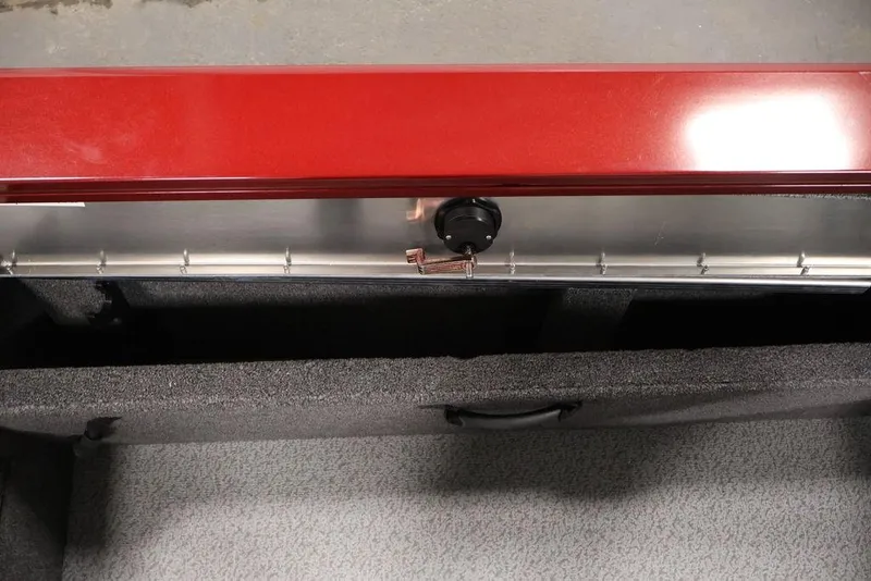 Slide: The Image of 2026 Lowe Fishing Machine 1875 storage compartment with red lid and secure latch. - 32