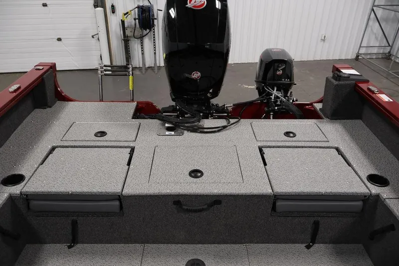 Slide: The Image of 2026 Lowe Fishing Machine 1875 boat interior with storage compartments and motor. - 38