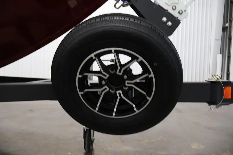 Slide: The Image of 2026 Lowe Fishing Machine 1875 trailer wheel with sleek black and silver rim design. - 43