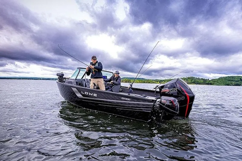 Slide: The Image of 2026 Lowe Fishing Machine 1875 on a lake under dramatic cloudy skies. - 50