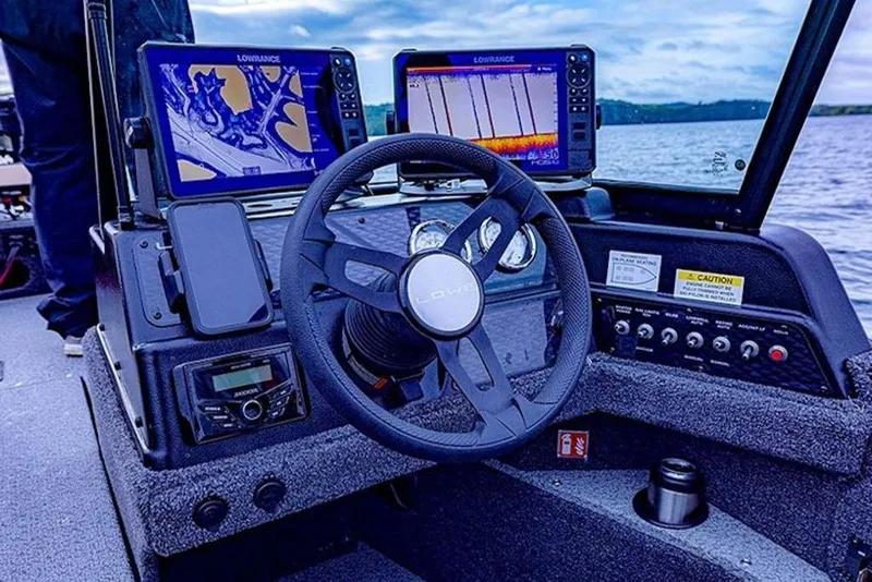 Slide: The Image of 2026 Lowe Fishing Machine 1875 dashboard with advanced navigation and sonar displays on a lake. - 53