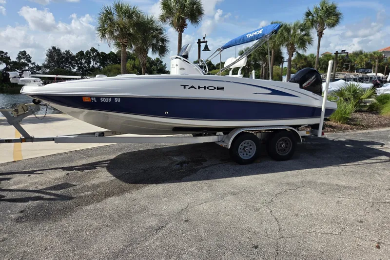 The Image of 2020 Tahoe 2150 CC boat on trailer, parked near palm trees under a clear sky. - 0