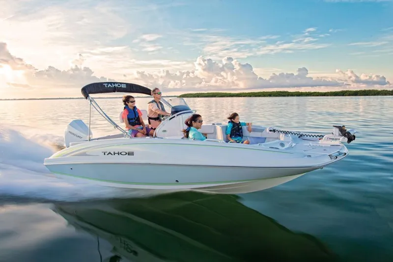 Slide: The Image of 2020 Tahoe 2150 CC boat cruising on calm water with passengers enjoying the ride. - 11