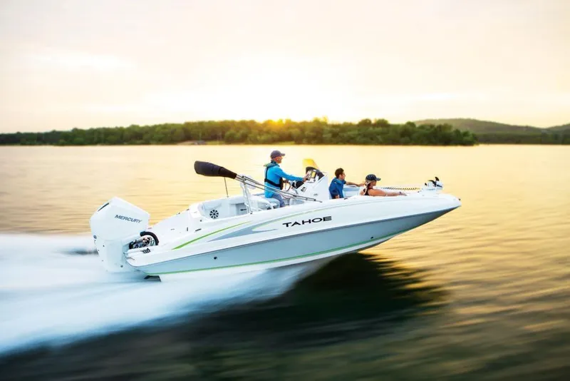 Slide: The Image of 2020 Tahoe 2150 CC boat speeding on a lake at sunset. - 16