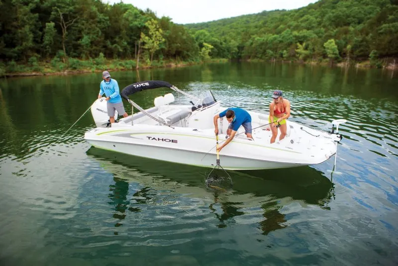 Slide: The Image of 2020 Tahoe 2150 CC boat on a serene lake with three people fishing. - 17