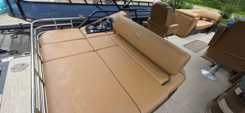 Slide: The Image of 2024 Regency 230 LE3 Sport pontoon boat with tan seating and modern controls. - 3
