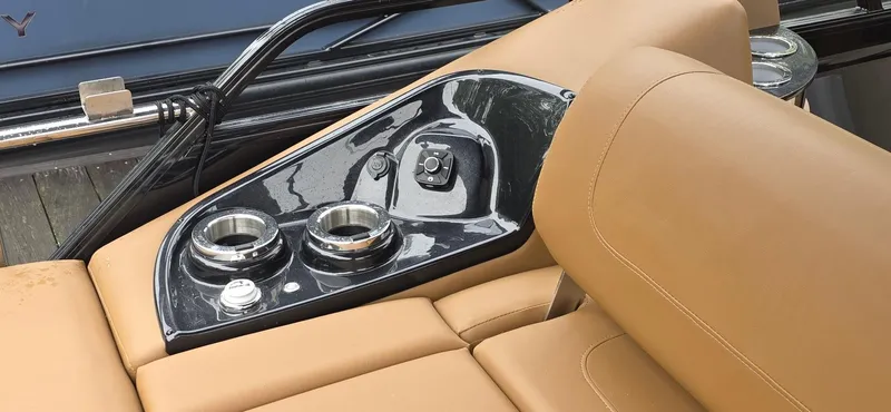 Slide: The Image of 2024 Regency 230 LE3 Sport boat interior with tan seating and control panel. - 8