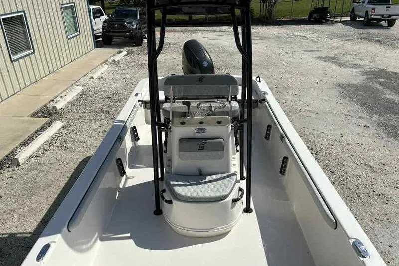 Slide: The Image of 2026 Carolina Skiff 21 LS boat, center console view, parked outdoors on gravel. - 11