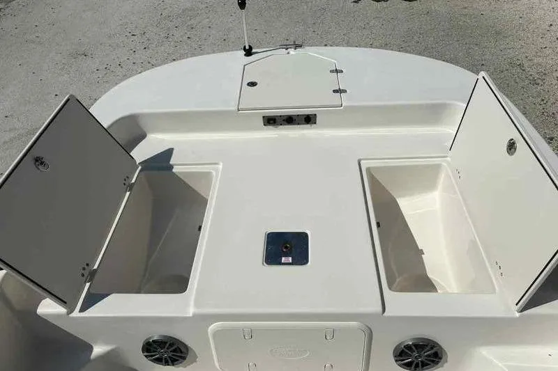 Slide: The Image of 2026 Carolina Skiff 21 LS boat deck with open storage compartments and speaker. - 17