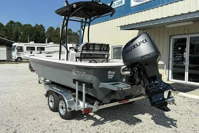 Slide: The Image of 2026 Carolina Skiff 21 LS boat with Suzuki outboard motor on trailer. - 2