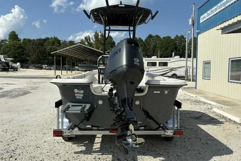 Slide: The Image of 2026 Carolina Skiff 21 LS boat with outboard motor on trailer, parked outdoors. - 3