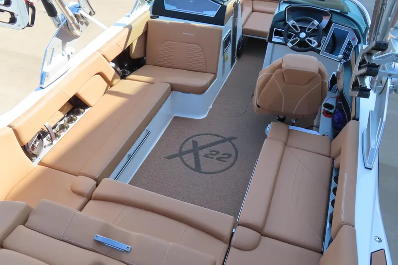 Slide: The Image of 2019 MasterCraft X22 boat interior with tan seating and modern dashboard. - 10