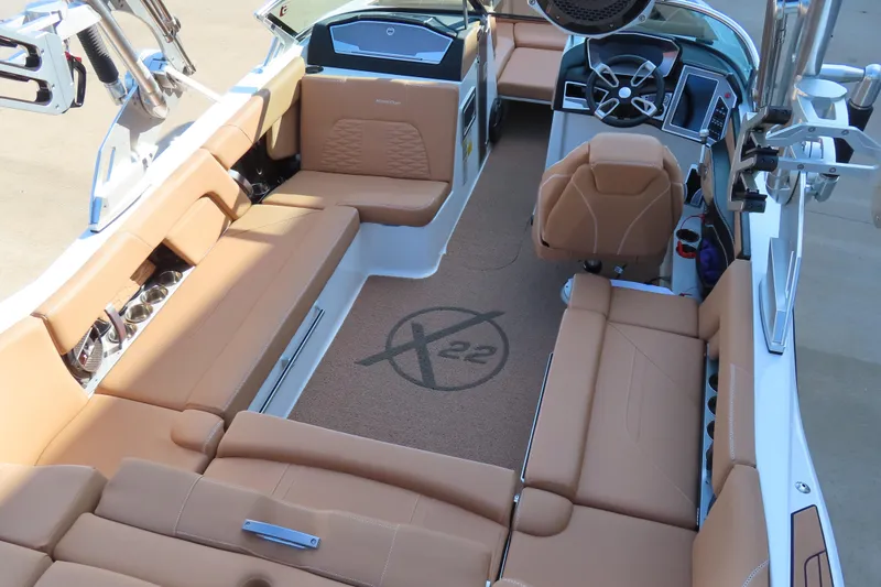 Slide: The Image of 2019 MasterCraft X22 boat interior with tan seating and modern dashboard. - 11