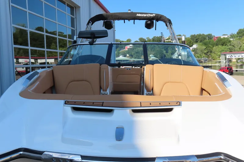 Slide: The Image of 2019 MasterCraft X22 boat with tan seating, docked near a building. - 6