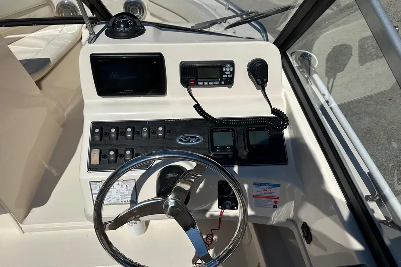 Slide: The Image of 2015 Grady-White Freedom 192 boat dashboard with steering wheel and control panel. - 4