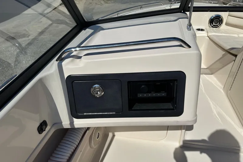 Slide: The Image of 2015 Grady-White Freedom 192 boat dashboard with storage compartment and audio system. - 9