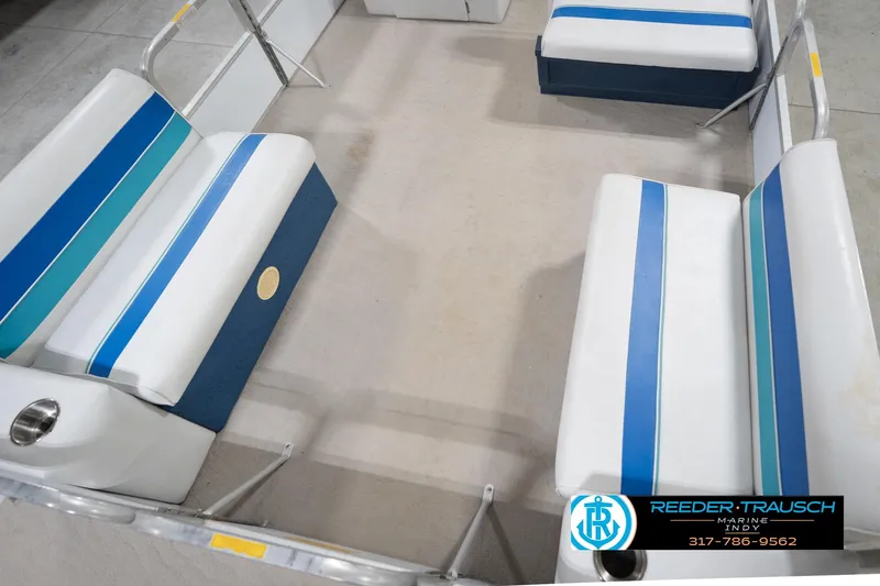 Slide: The Image of 1996 Godfrey Sweetwater 180 EX pontoon boat with blue canopy in indoor storage. - 11