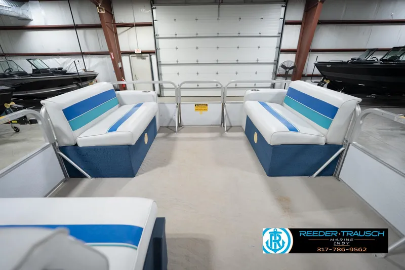 Slide: The Image of 1996 Godfrey Sweetwater 180 EX boat interior with blue and white seating in showroom. - 19