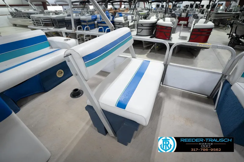 Slide: The Image of 1996 Godfrey Sweetwater 180 EX boat interior with blue and white seating in a showroom. - 22