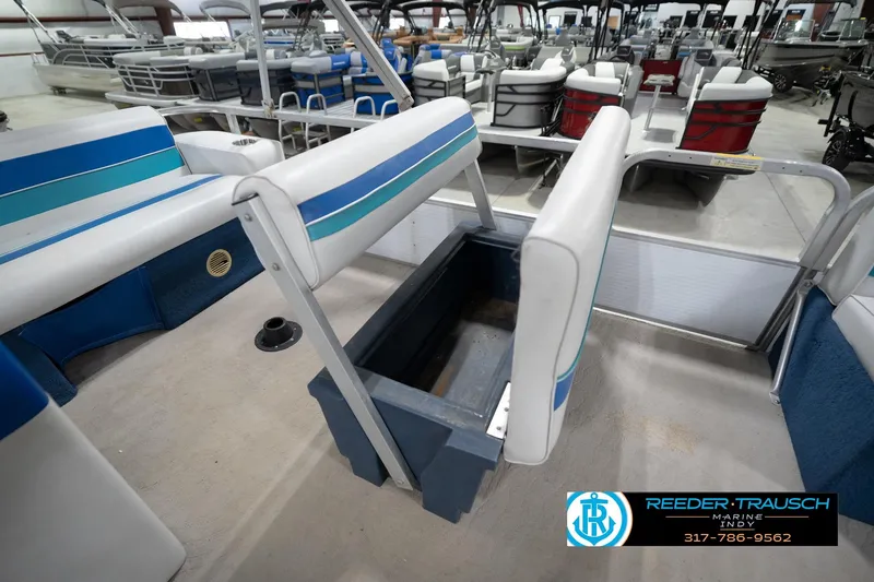 Slide: The Image of 1996 Godfrey Sweetwater 180 EX boat interior with blue and white seating in a garage. - 23