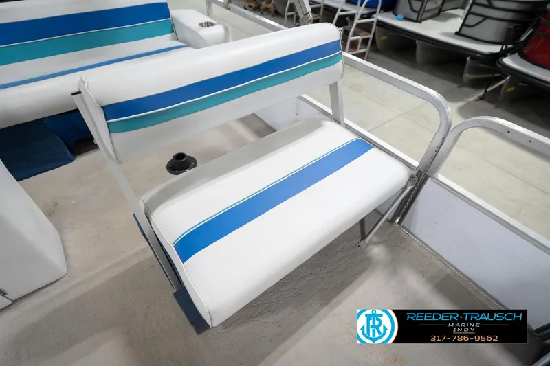 Slide: The Image of 1996 Godfrey Sweetwater 180 EX boat interior with blue and white seating in a showroom. - 34