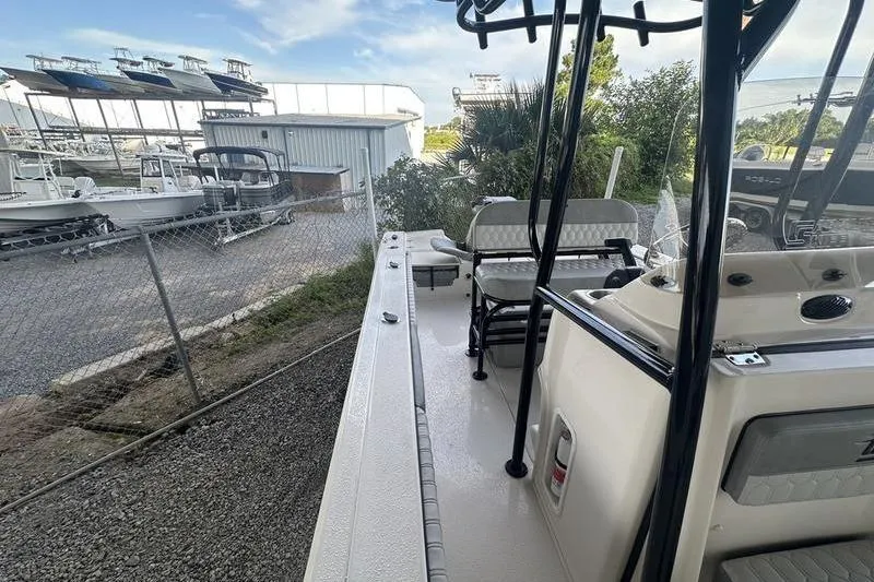 Slide: The Image of 2026 Carolina Skiff 24 Ultra Elite boat docked near storage facility. - 11