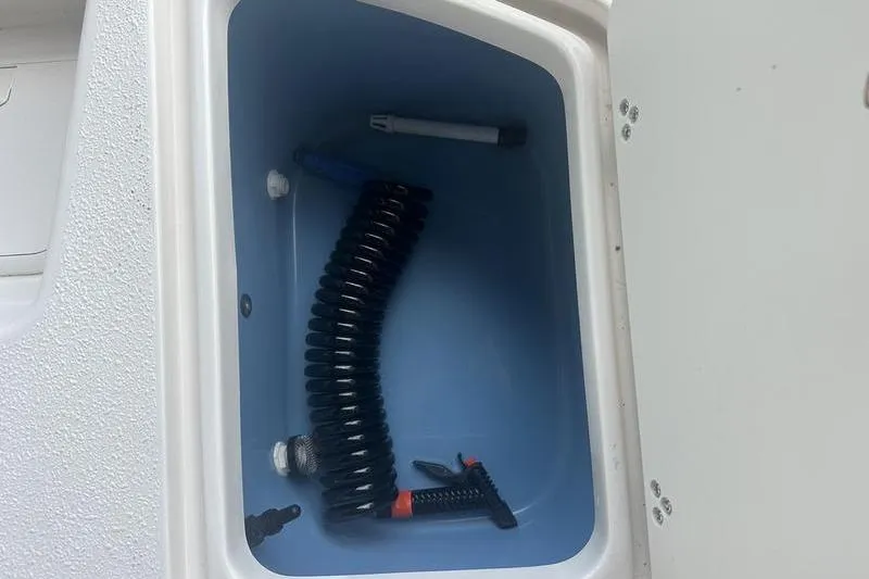 Slide: The Image of Storage compartment with coiled hose in 2026 Carolina Skiff 24 Ultra Elite boat. - 12