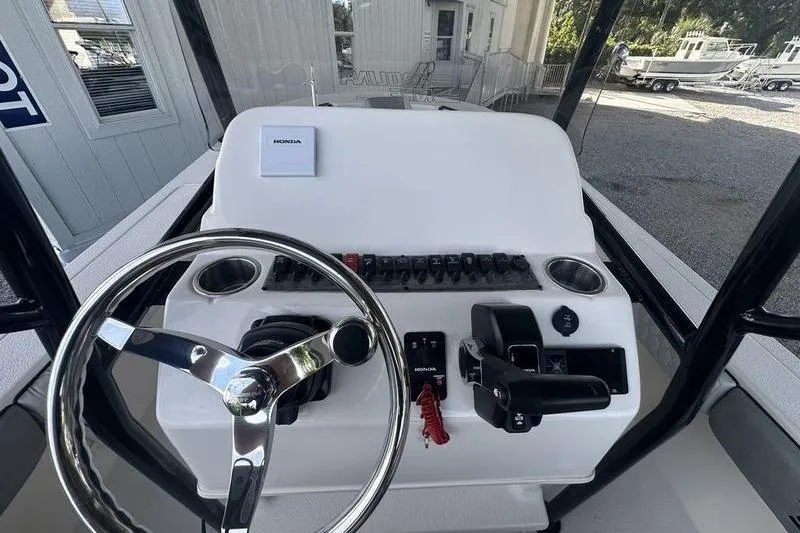 Slide: The Image of 2026 Carolina Skiff 24 Ultra Elite boat console with steering wheel and controls. - 17