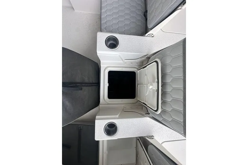 Slide: The Image of 2026 Carolina Skiff 24 Ultra Elite boat interior with open storage compartment and cup holders. - 18