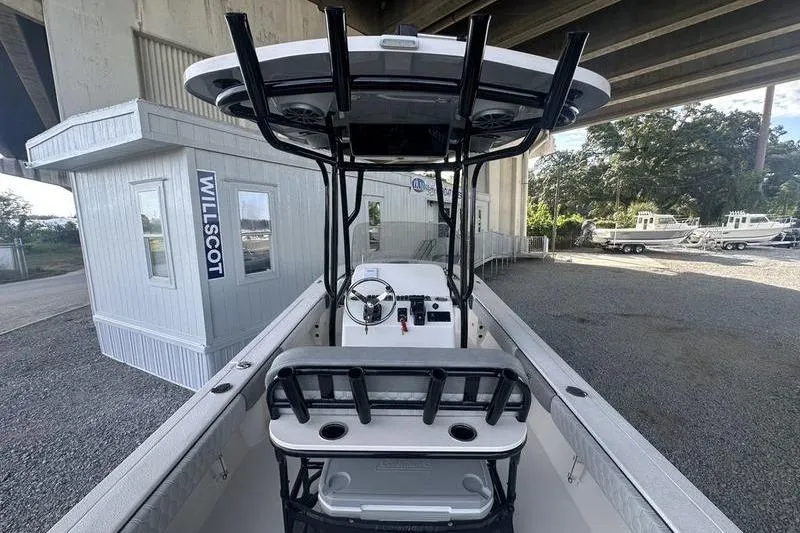 Slide: The Image of 2026 Carolina Skiff 24 Ultra Elite boat under bridge, showcasing helm and seating area. - 19