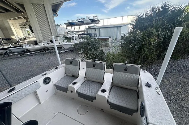 Slide: The Image of 2026 Carolina Skiff 24 Ultra Elite boat interior with seating, docked near storage facility. - 22