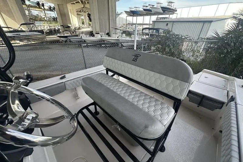 Slide: The Image of 2026 Carolina Skiff 24 Ultra Elite boat interior with steering wheel and cushioned seating. - 25