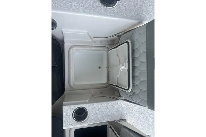 Slide: The Image of 2026 Carolina Skiff 24 Ultra Elite boat storage compartment with cup holder. - 5