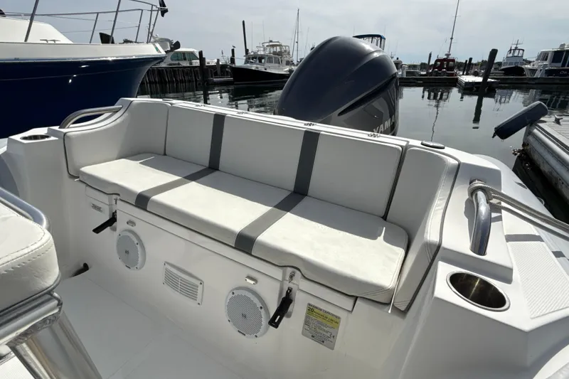 Slide: The Image of 2020 AB Inflatables Oceanus 21 VST boat with cushioned seating and speakers at a marina. - 13