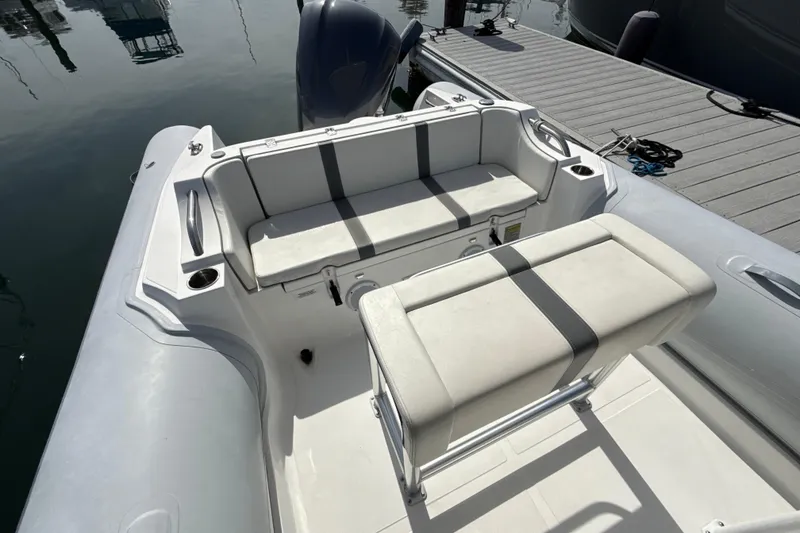Slide: The Image of 2020 AB Inflatables Oceanus 21 VST boat interior with seating and console, docked by the water. - 10