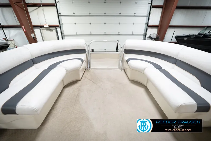 Slide: The Image of 2008 Misty Harbor 2085CR pontoon boat interior with white and gray seating in a garage. - 21