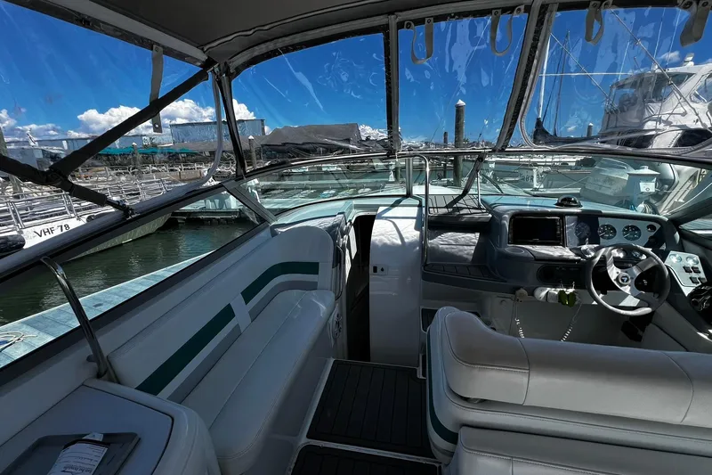 Slide: The Image of 1997 Formula 330 Sun Sport boat interior with steering wheel and seating at marina. - 4