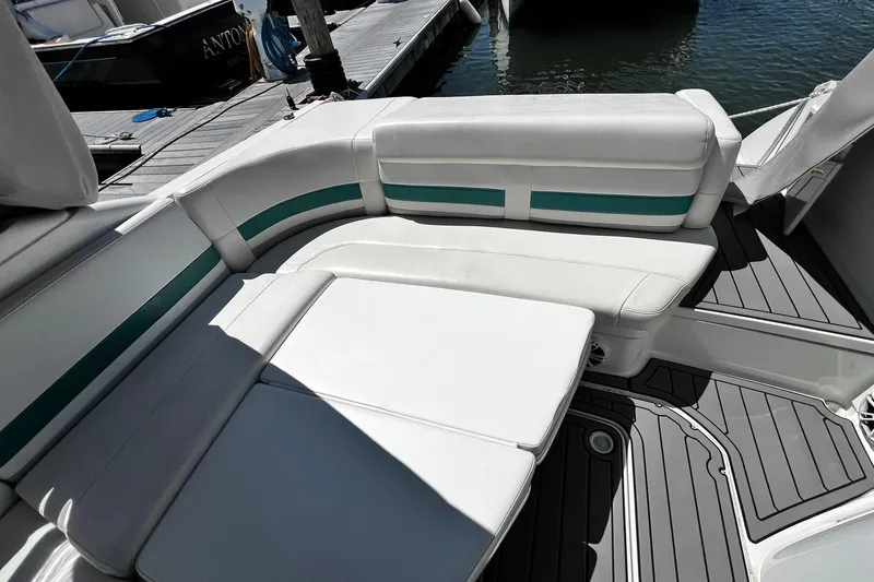 Slide: The Image of 1997 Formula 330 Sun Sport boat interior with white and teal seating at a dock. - 6