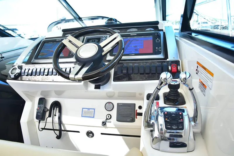 Slide: The Image of Control panel of 2013 Sea Ray 410 Sundancer yacht with steering wheel and navigation screens. - 42