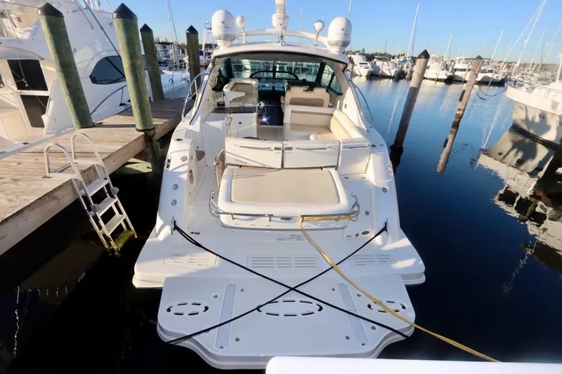 Slide: The Image of 2013 Sea Ray 410 Sundancer yacht docked at marina, rear view showing spacious deck. - 6