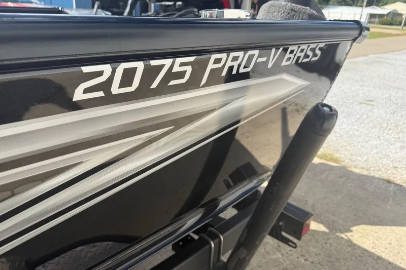 Slide: The Image of 2021 Lund 2075 Pro-V Bass boat, sleek black design with bold graphics. - 12