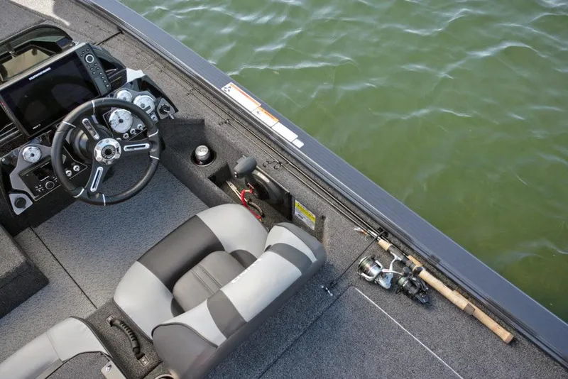 Slide: The Image of Manufacturer Provided Image: 2021 Lund 2075 Pro-V Bass boat interior with steering wheel and fishing rods. - 23