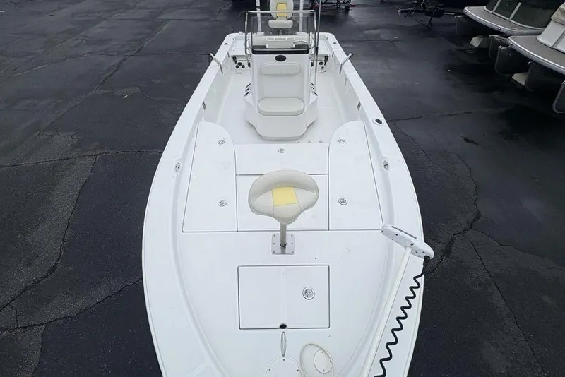 Slide: The Image of 2003 Ranger 2300 Bay Ranger boat, white deck, center console, docked on asphalt surface. - 29