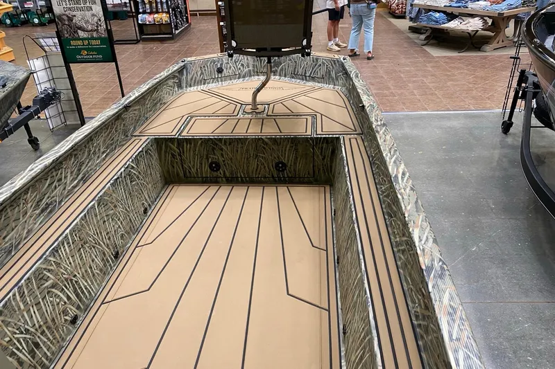 Slide: The Image of 2026 Tracker Grizzly 1650 T Prairie Wings Edition boat displayed indoors. - 3