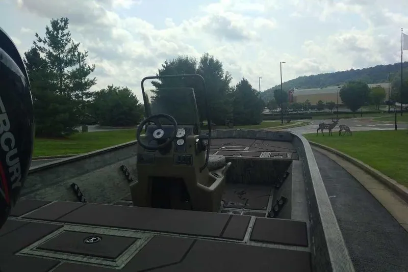 Slide: The Image of 2026 Tracker Grizzly 2072 CC boat on trailer, parked outdoors near trees and deer. - 2