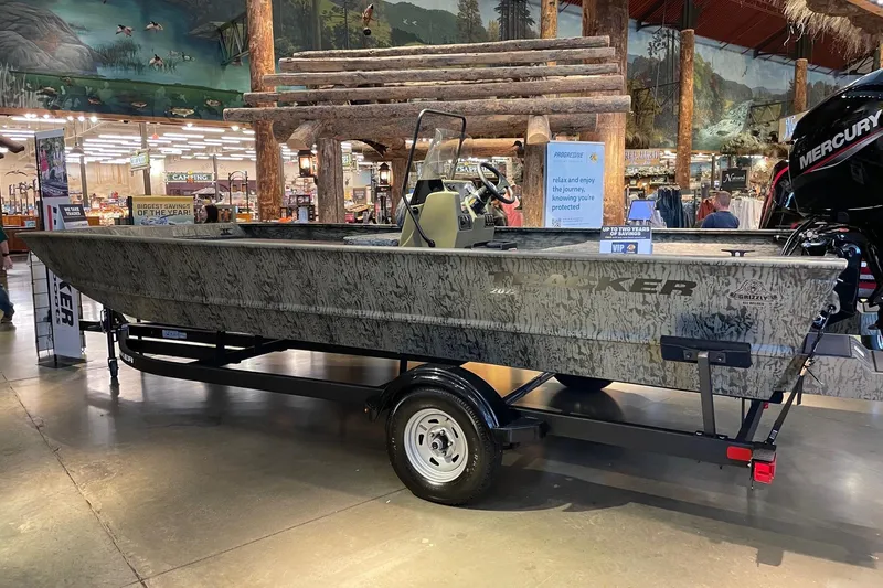 Slide: The Image of 2026 Tracker Grizzly 2072 CC boat displayed indoors on a trailer. - 3