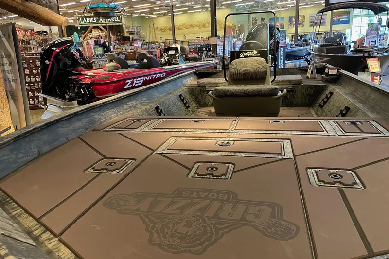 Slide: The Image of 2026 Tracker Grizzly 2072 CC boat interior at a showroom, featuring spacious seating and storage. - 4