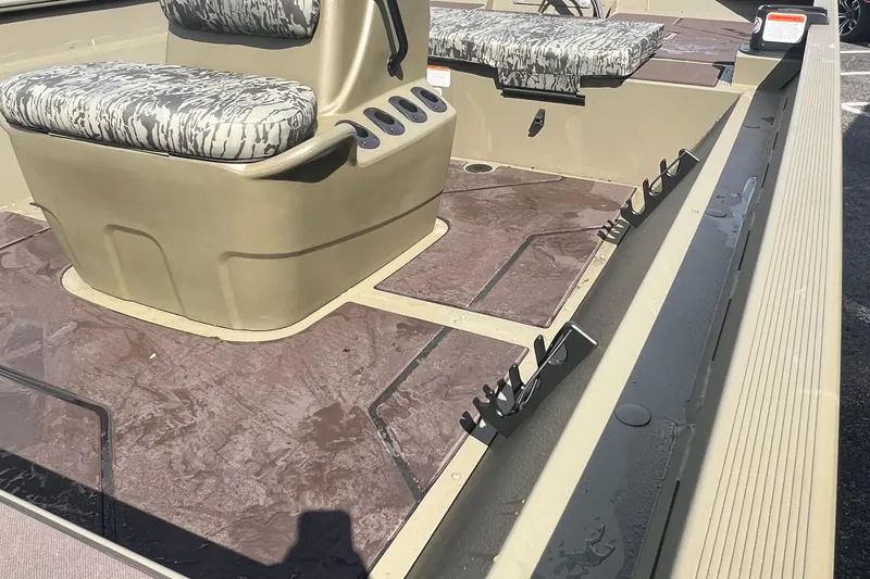 Slide: The Image of 2026 Tracker Grizzly 2072 CC boat interior with camo seats and rod holders. - 10
