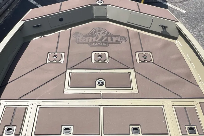 Slide: The Image of 2026 Tracker Grizzly 2072 CC boat deck with storage compartments and Grizzly Boats logo. - 3