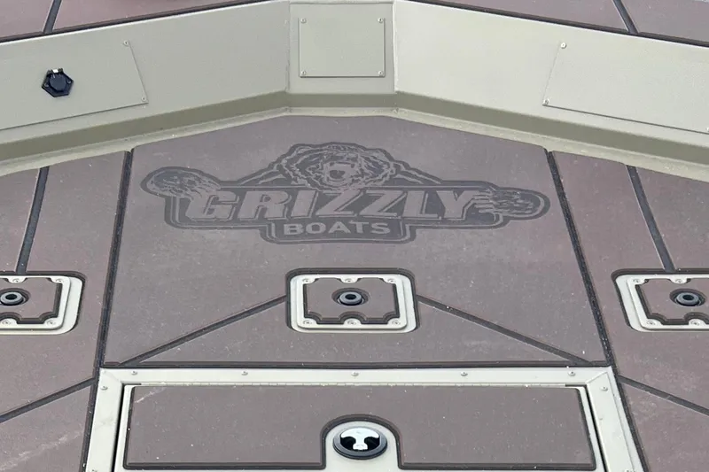 Slide: The Image of Deck of 2026 Tracker Grizzly 2072 CC boat with logo and storage compartments. - 4